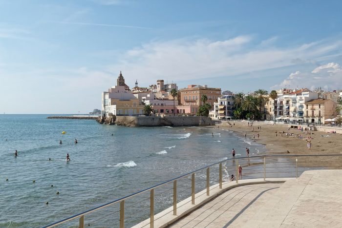 Playa de Sitges con el casco antiguo y la iglesia de Sant Bartomeu i Santa Tecla al fondo