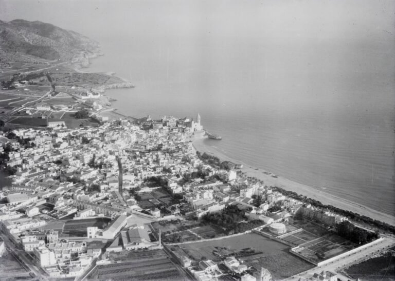 Vista aérea histórica de Sitges hacia 1930, con el caserío blanco junto al mar